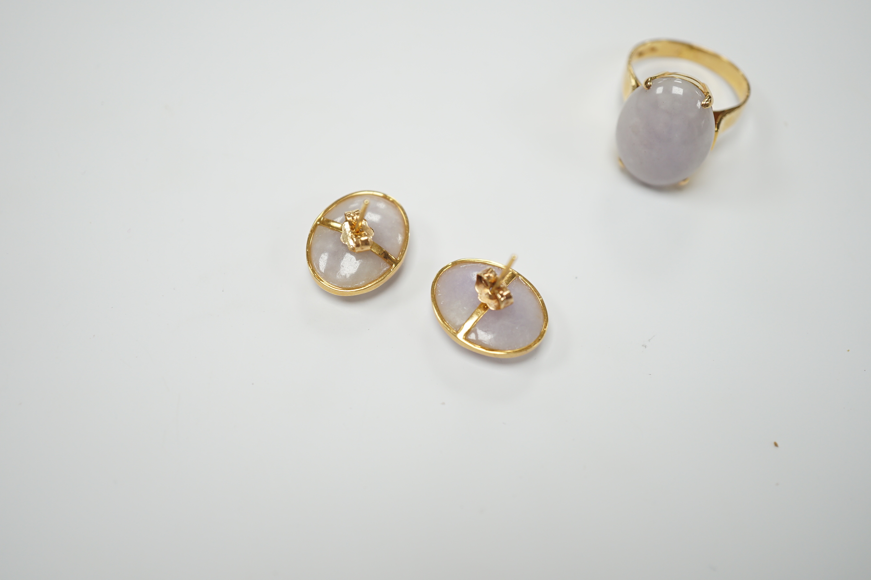 A 14k yellow metal and oval white cabochon jade set ring, size M/N and pair of matching earrings, gross weight 9.7 grams.